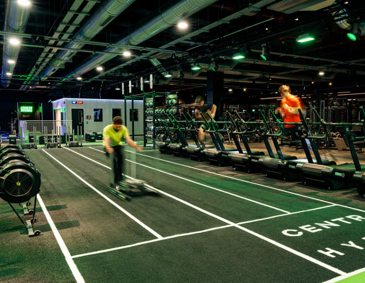 The HYROX turf lane at XF Liverpool, a member pushing a sled
