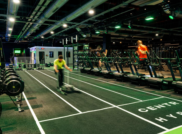 The HYROX turf lane at XF Liverpool, a member pushing a sled