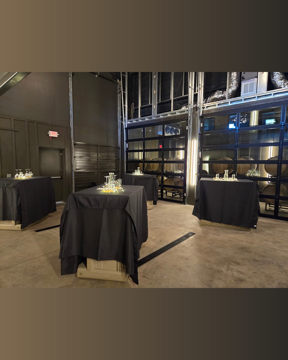 The Barrel Room set up for a live music night, high-top tables and decanters