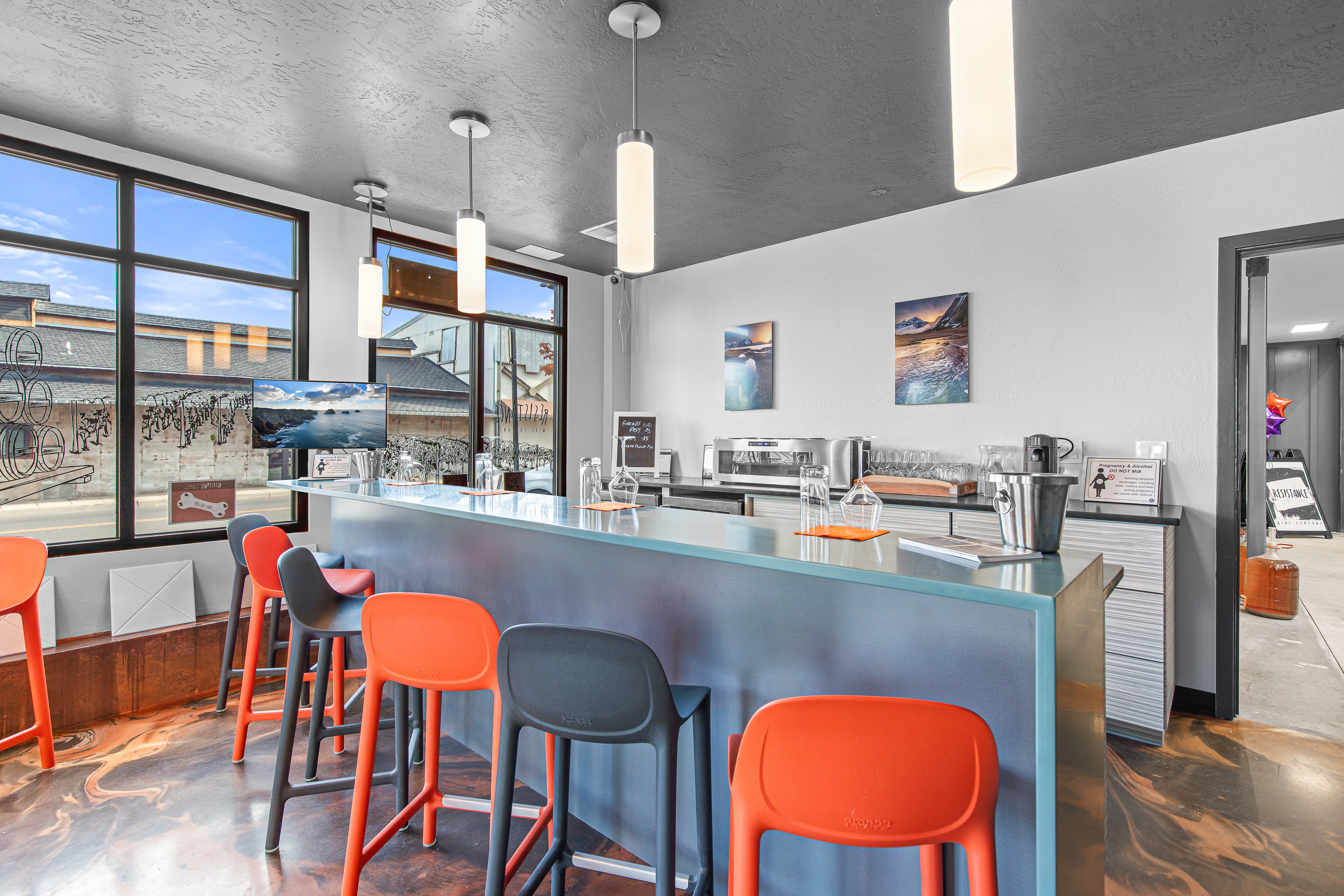 The Resistance Wine Co. tasting room in downtown Ashland, with bottles lined along the bar and seating for guests.
