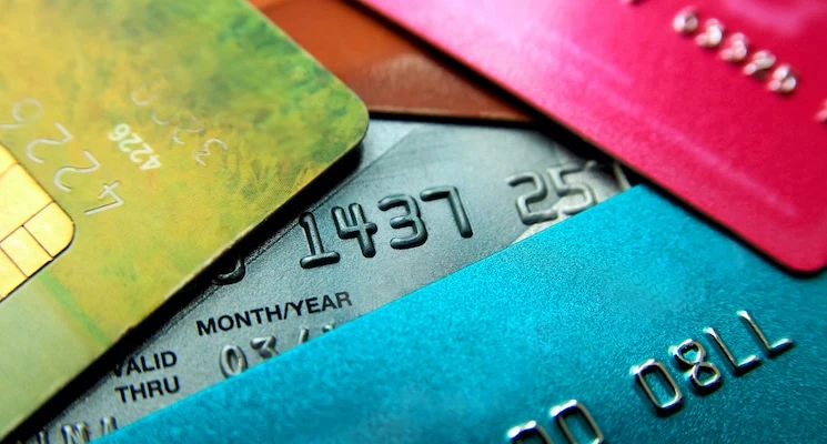 Stack of multicolored credit cards close-up view with selective focus.