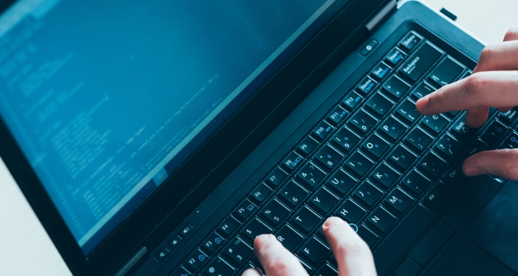 Man typing coding on laptop