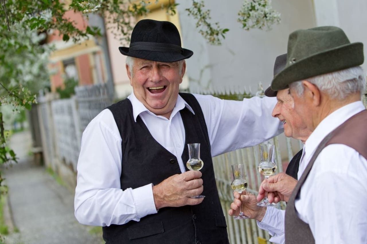 3 old man drinking pálinka in rural Hungary