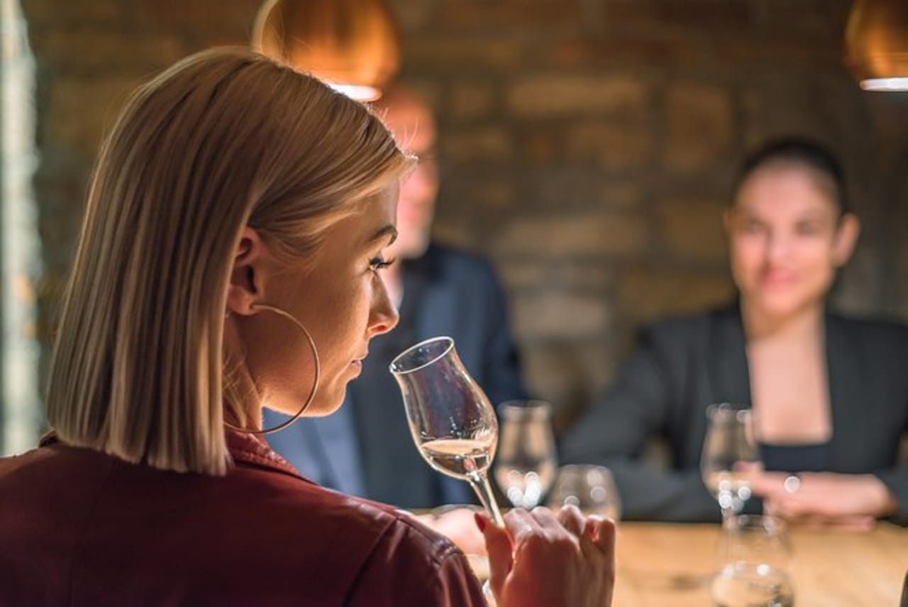 Woman smelling palinka in tulip glass