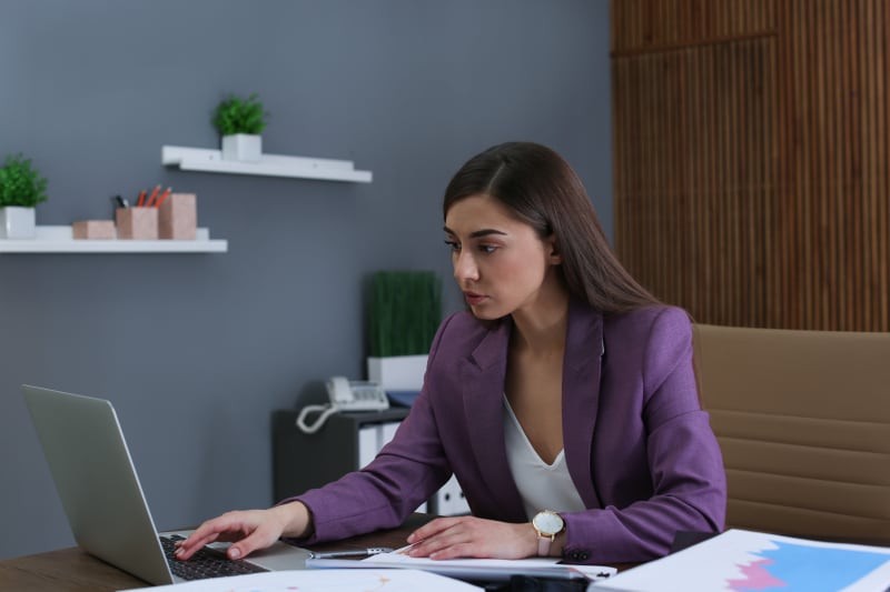 Businesswoman working with laptop and documents