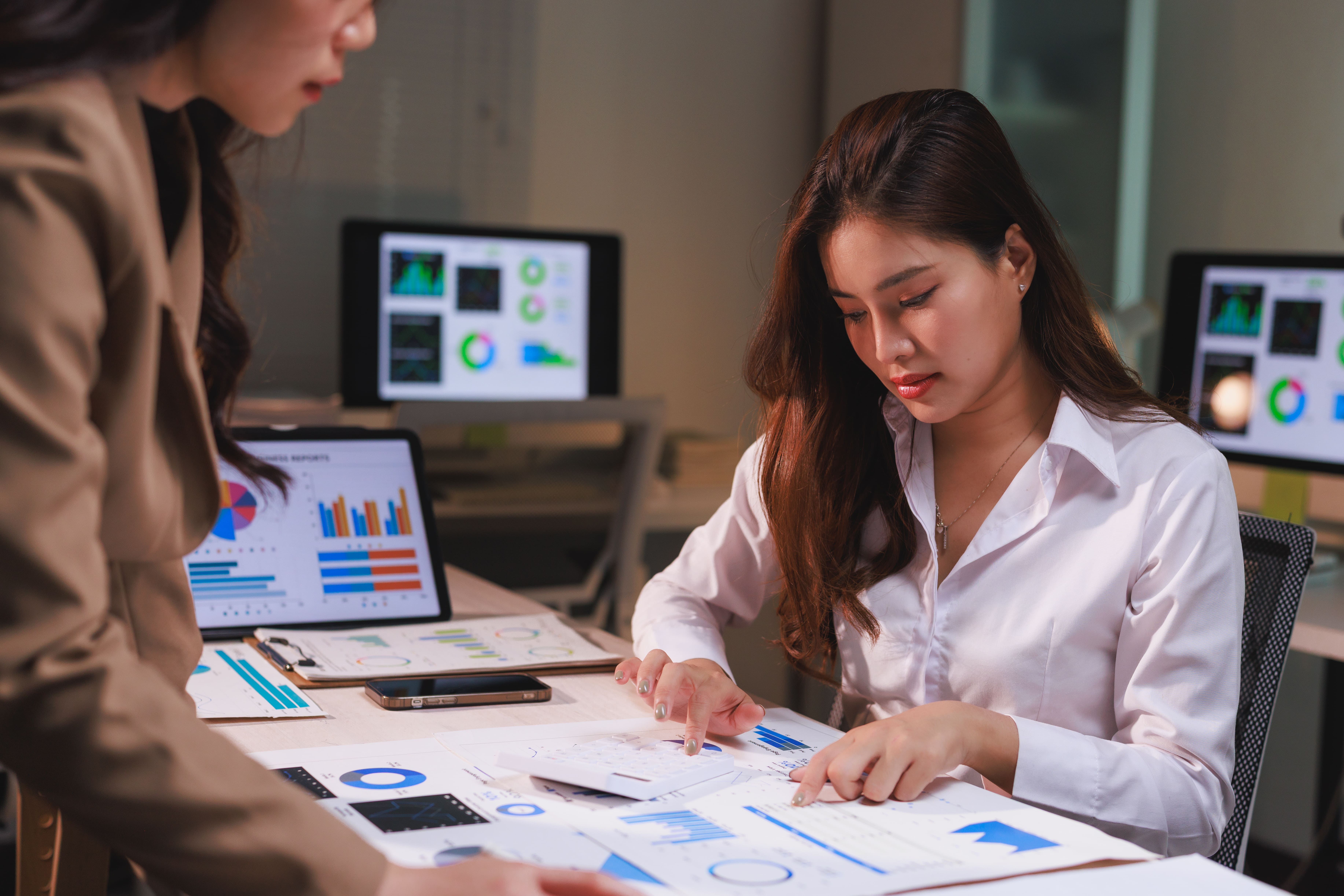 Businesswomen analyzing financial data documents