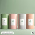 Four cylindrical tea canisters in green and pink tones on a green background.