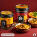 Black and red lidded containers with chicken korma and curry bowls.