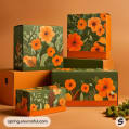 Stacked green and orange mailer boxes with floral patterns featuring orange flowers and green leaves on an orange background.