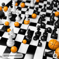 Close-up of a chess board with mixed color pieces and basketballs.