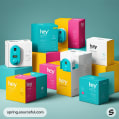 Variety of boxes in white, teal, pink, and yellow with electronic devices on top, on a teal background.