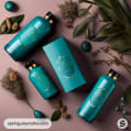 Turquoise bottles and box with gold accents surrounded by plants on a dark surface.