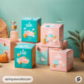 Various pastel boxes with cute illustrations and green plant on a soft background.