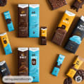 Assorted chocolate bars with blue, brown, and yellow packaging on a brown backdrop.