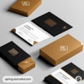 Business card set in black and gold with matching envelope and box on a grey background.