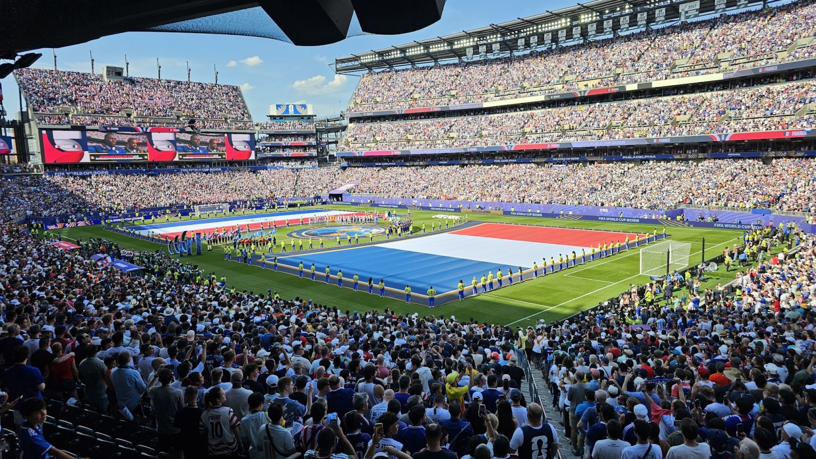 A giant French flag unfurled across the pitch at Lincoln Financial Field before the France vs. Paraguay Round of 16 match, stadium packed to capacity