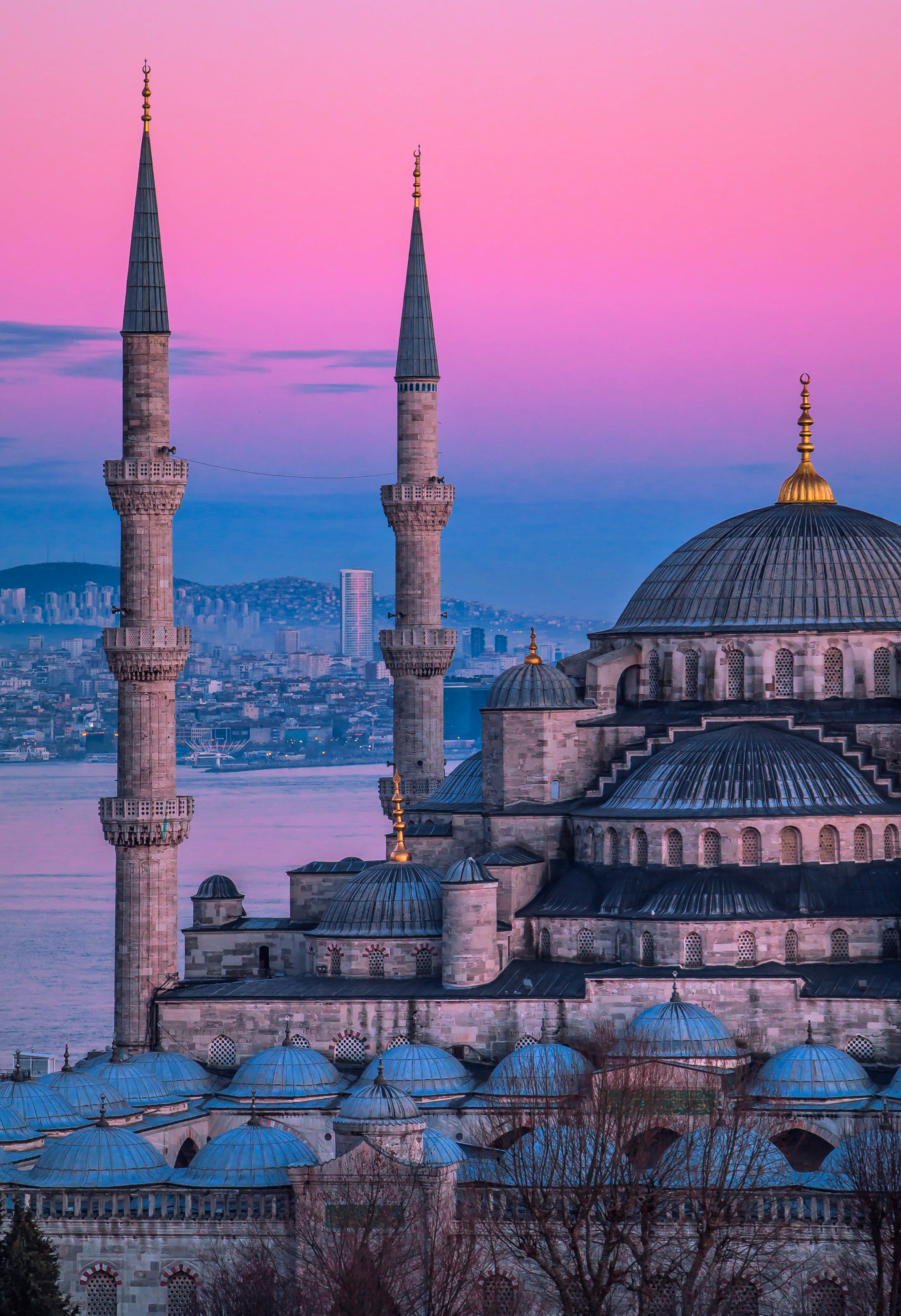 The Istanbul skyline at dusk, minarets and domes reflected in the Bosphorus
