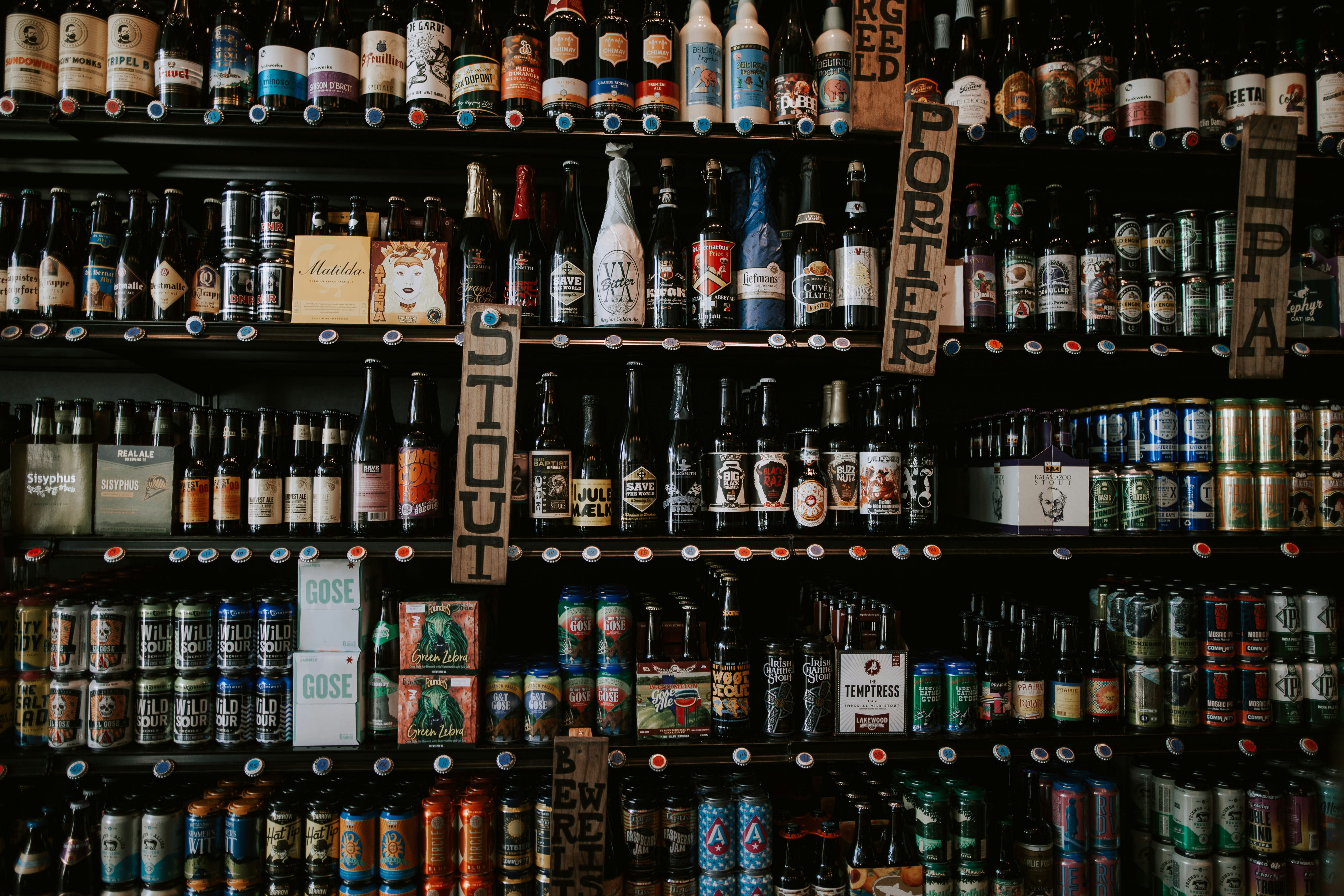 A wall of craft and Belgian beer bottles organized by style