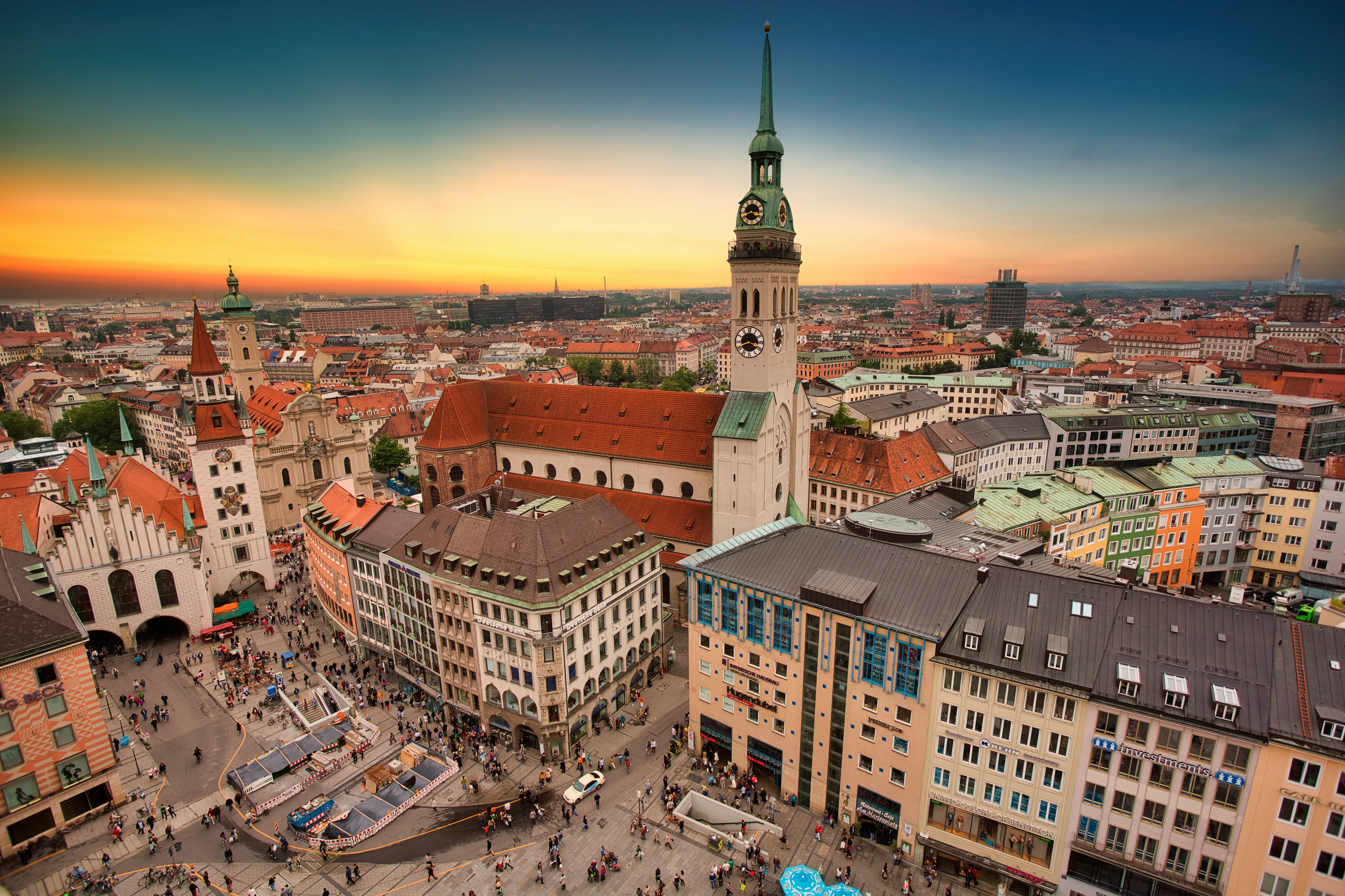 Munich's Marienplatz at sunset, with St. Peter's Church tower rising over the old town