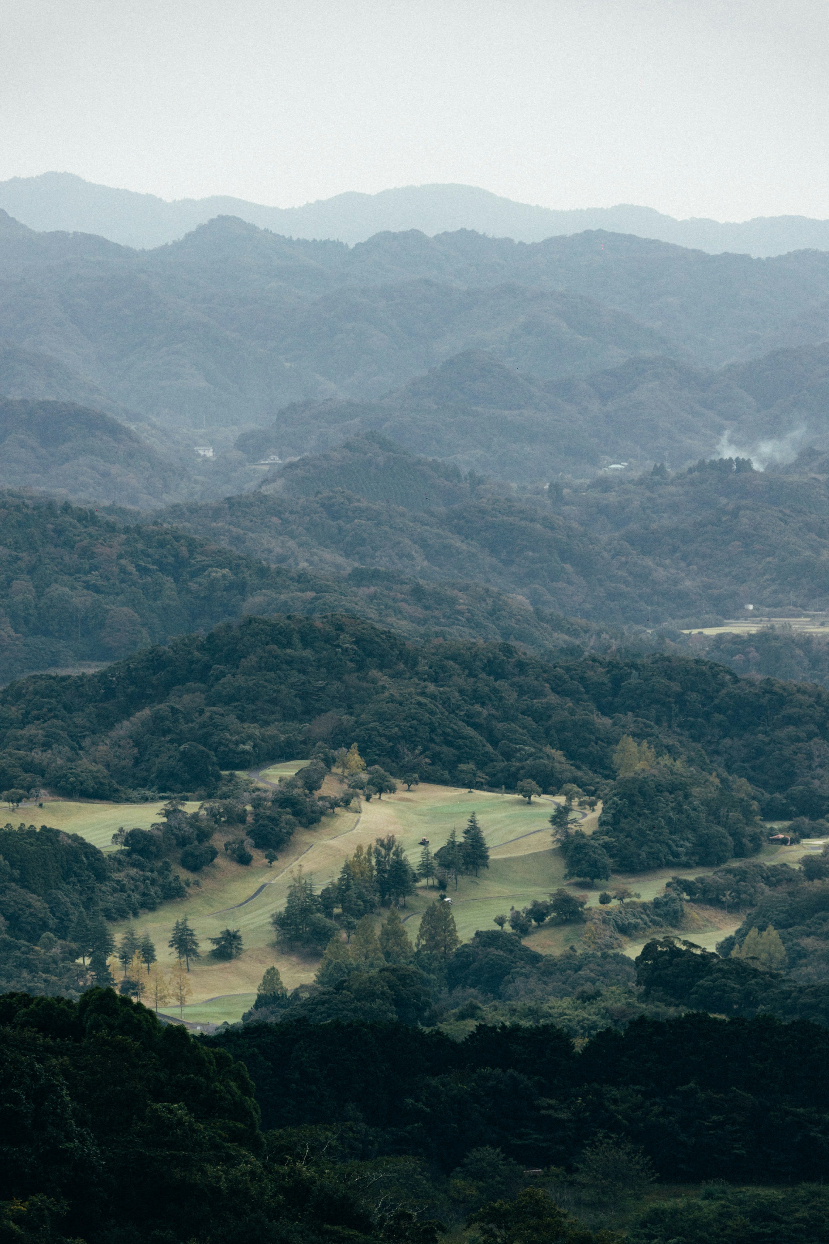 Golf course carved into the forested Japanese mountains