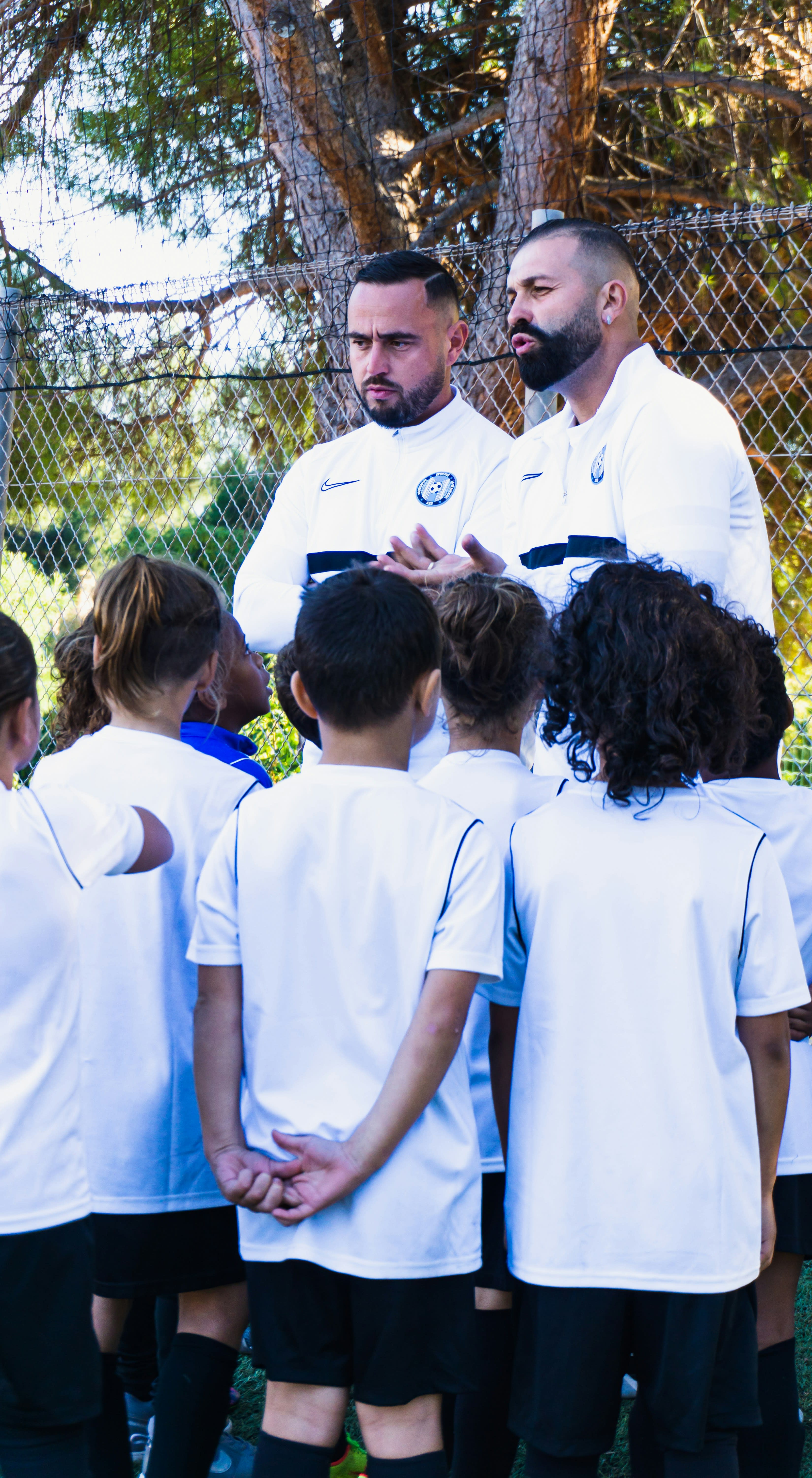 Professional coaches giving a team briefing to young soccer players