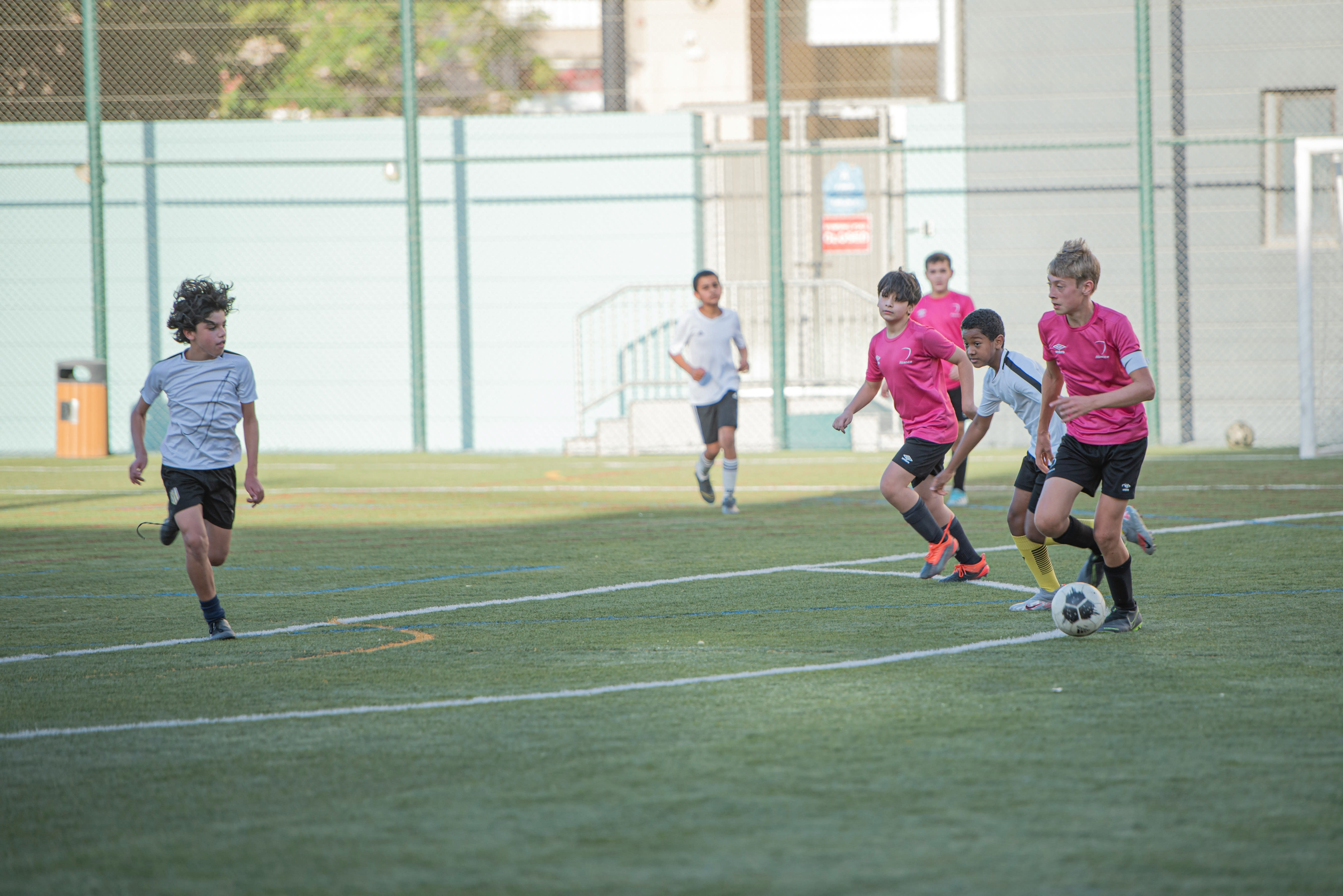 Youth players competing in an evening match under stadium lights