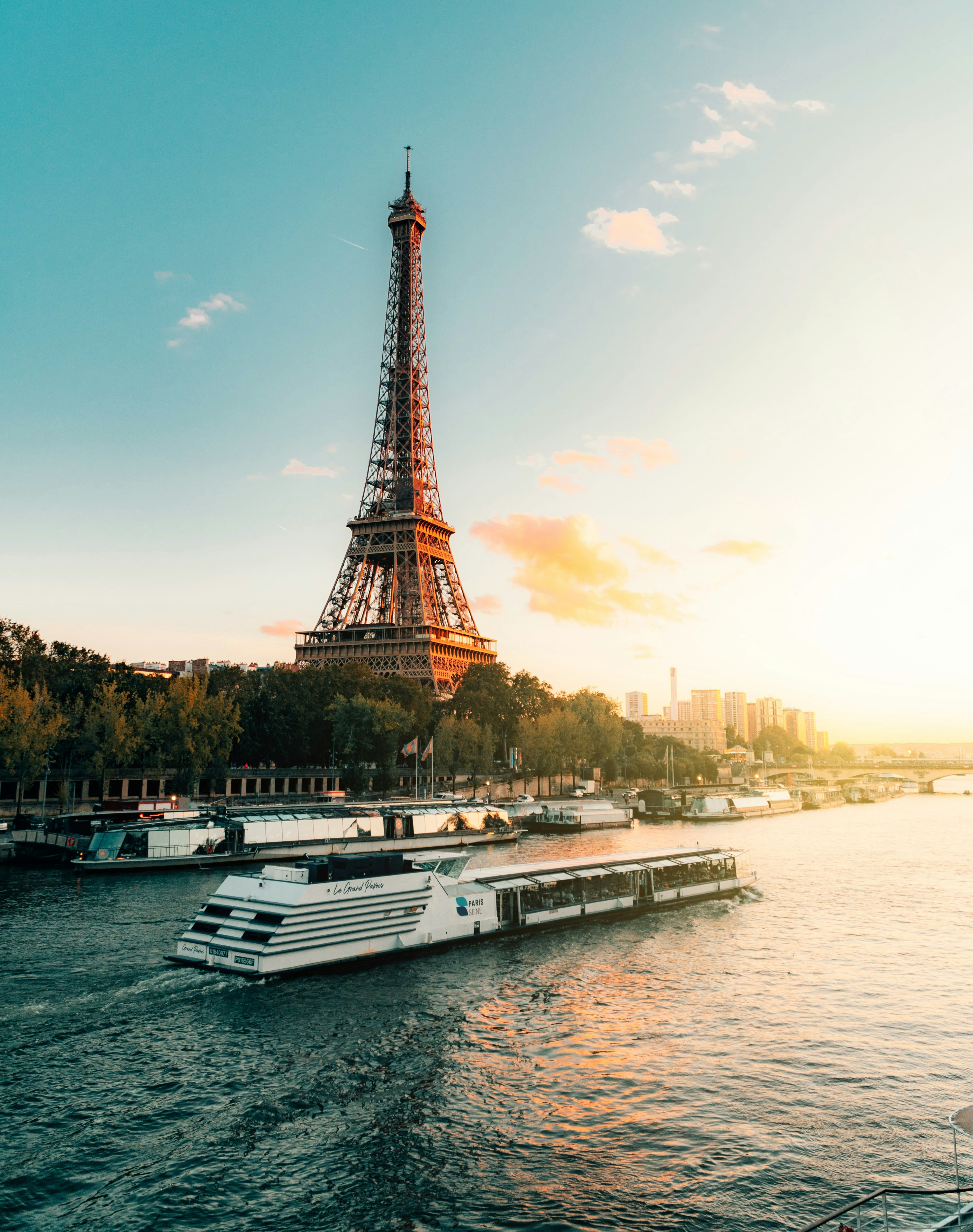 Eiffel Tower at sunset with a Seine cruise boat in the foreground
