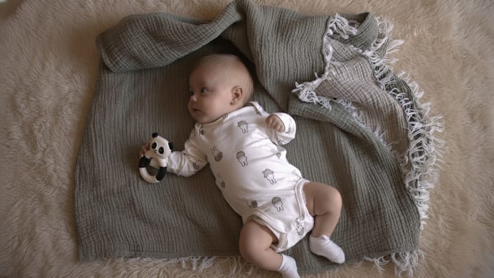 Hubble panda şeklinde diş kaşıyıcısı olan sarışın bebek, diş çıkarma sırasında yumruk çiğnemenin güvenli alternatifini gösteriyor.