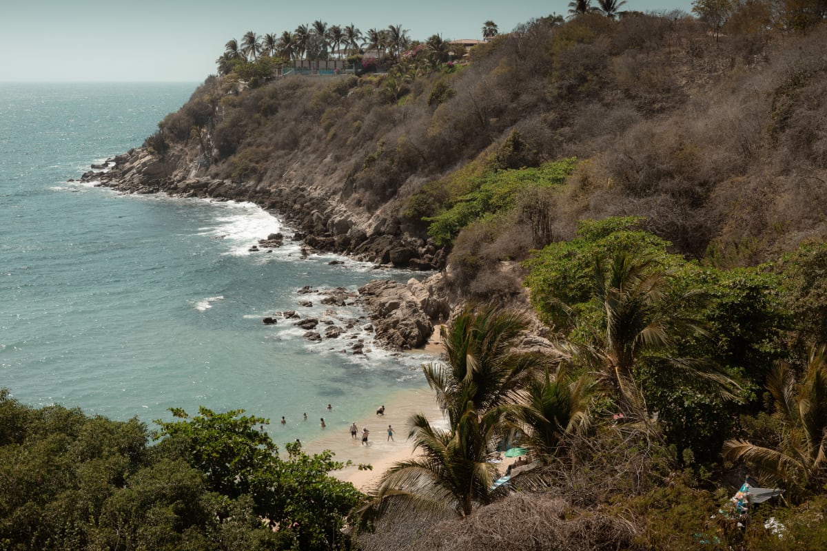 Small cove with swimmers seen from the hillside above, a Puerto Escondido view that ocean view rentals sell
