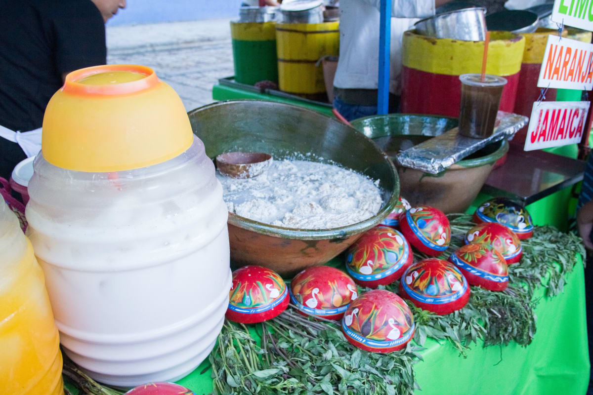 Tejate and aguas frescas served in painted gourds at a street stand in Oaxaca