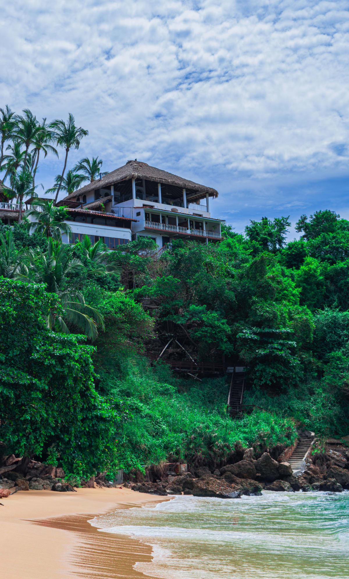 A tropical beachfront hotel property in Puerto Escondido, Mexico surrounded by lush greenery