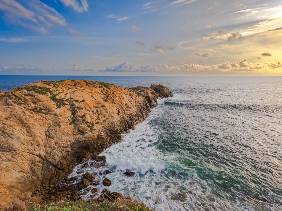 Waves breaking against a rocky point at sunset on the Oaxaca coast near Mazunte