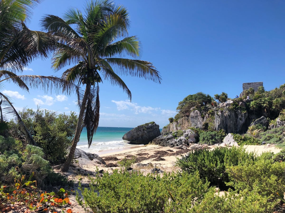 Playa de Tulum con ruinas mayas sobre el Mar Caribe, palmeras y aguas turquesa — mercado inmobiliario de Tulum