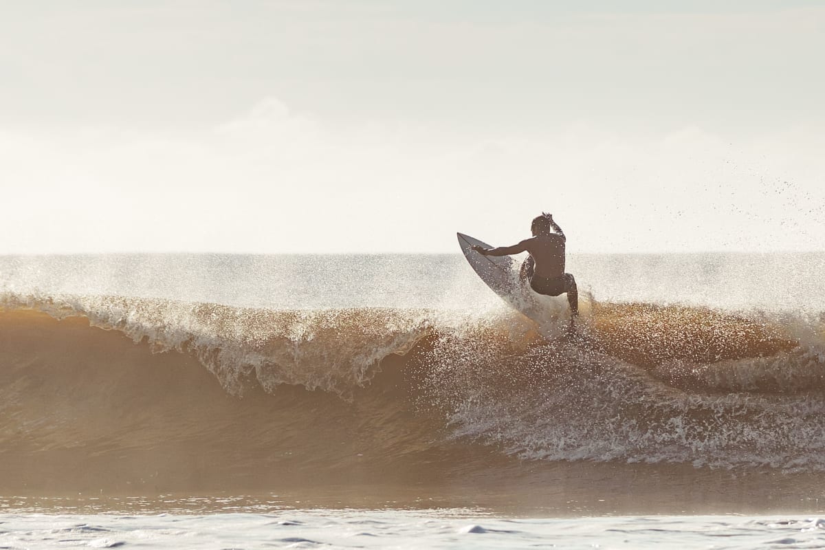 Surfer catching a wave under clear sky — surf lifestyle Puerto Escondido Oaxaca