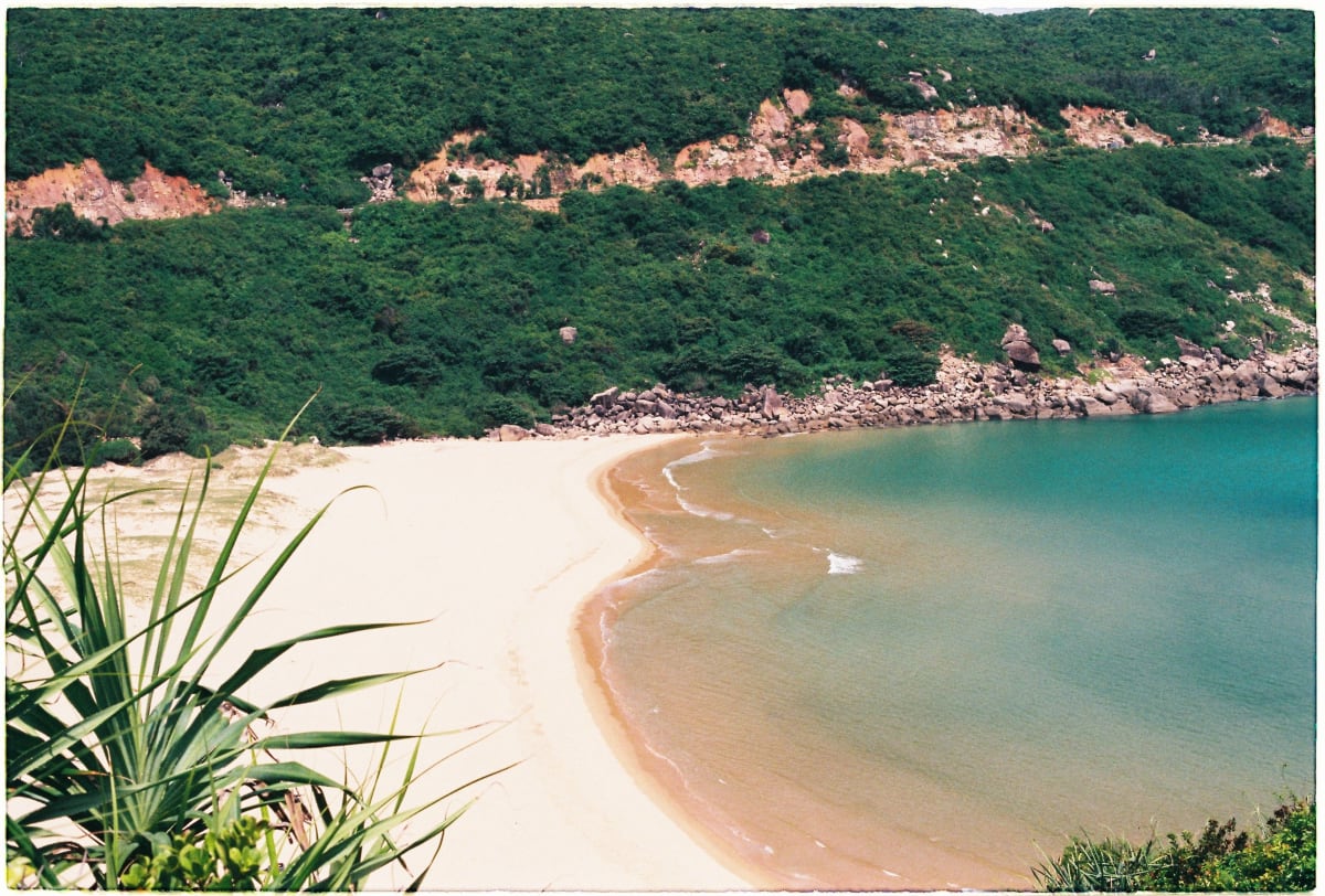 Quiet tropical beach cove with golden sand and turquoise water, illustrating the sheltered bay character of Manzanillo sector real estate Puerto Escondido compared to open-ocean surf beaches