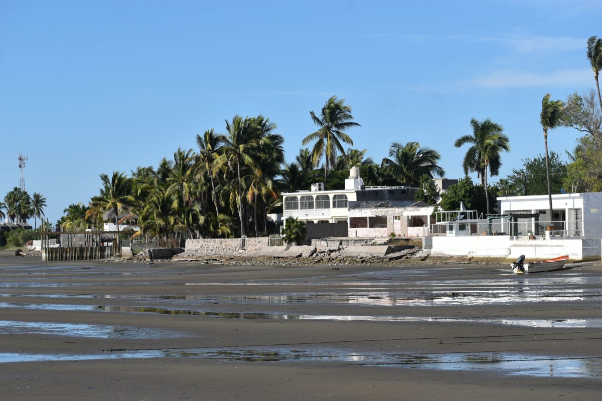 Casas frente al mar con palmeras en un día soleado en la costa del Pacífico mexicano