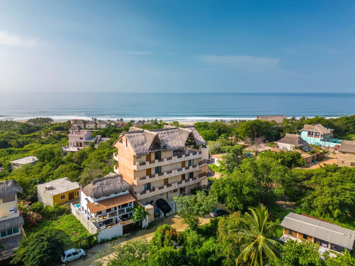 Vue aérienne d'un immeuble de condos avec vue sur l'océan à vendre à Puerto Escondido, Oaxaca — l'une des annonces réelles à 200 000 USD présentées dans ce guide, à quelques pas du Pacifique