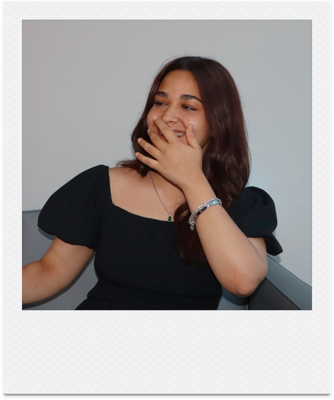 Seba laughing with her hand near her face