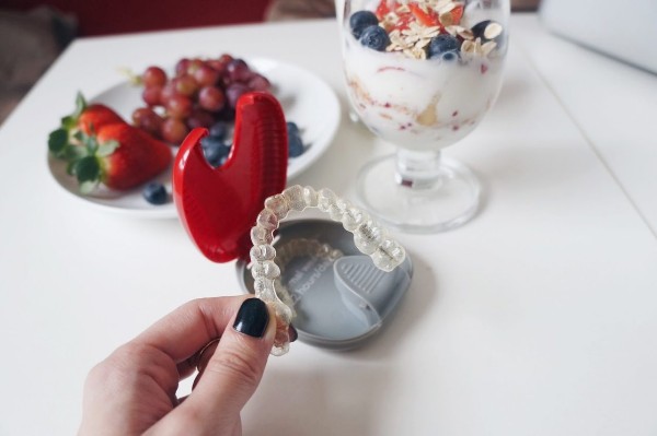 woman at dinner table with clear aligners