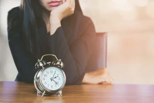 Woman waiting with clock