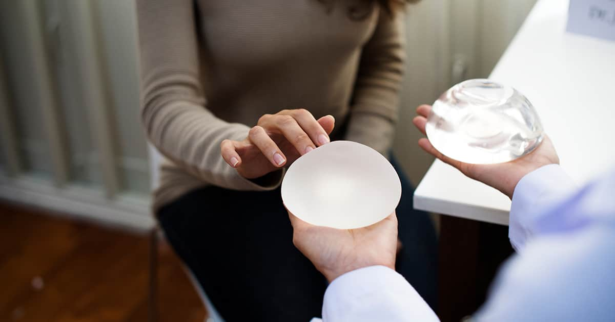 a patient talking to a doctor about silicone versus saline breast implants