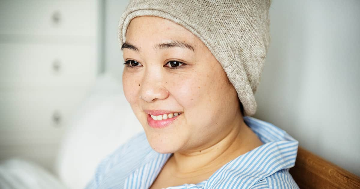 a smiling woman with a knitted cap