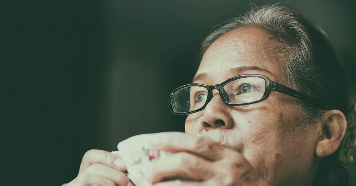 old woman with glasses drinking tea