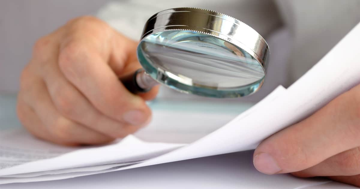 a person checking a document with a magnifying glass