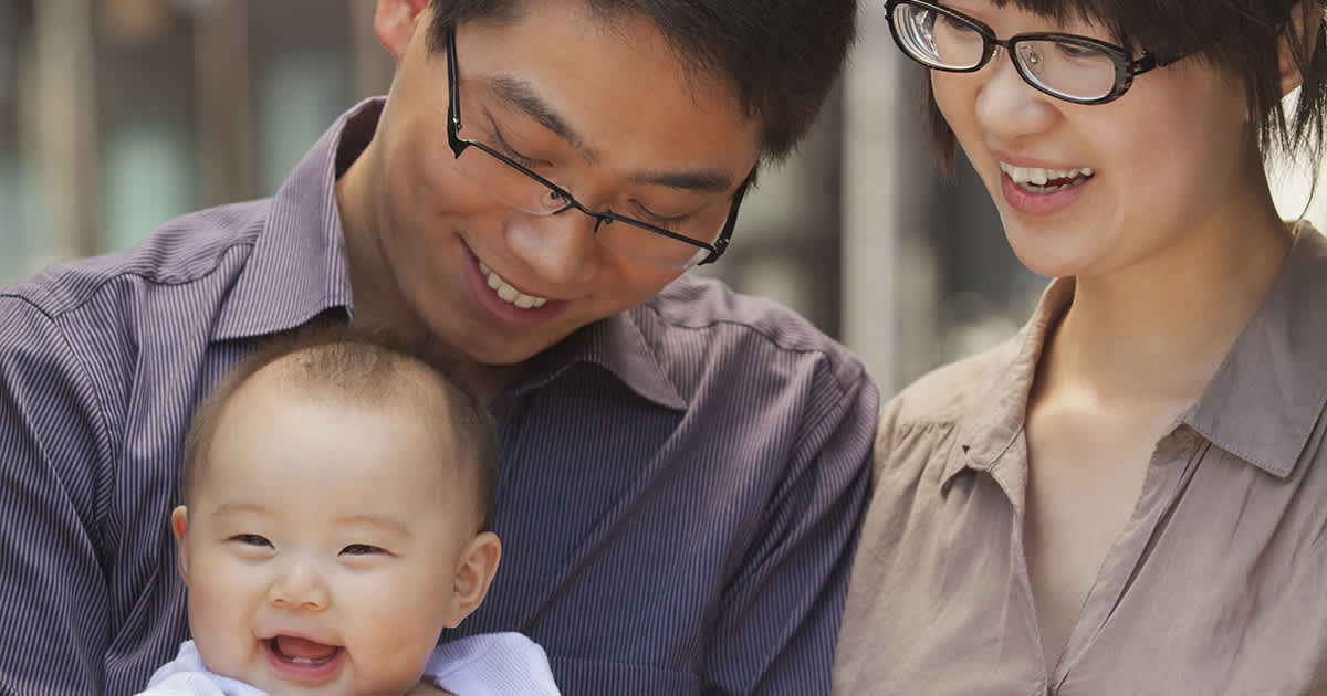 two young chinese parents with glasses and a baby