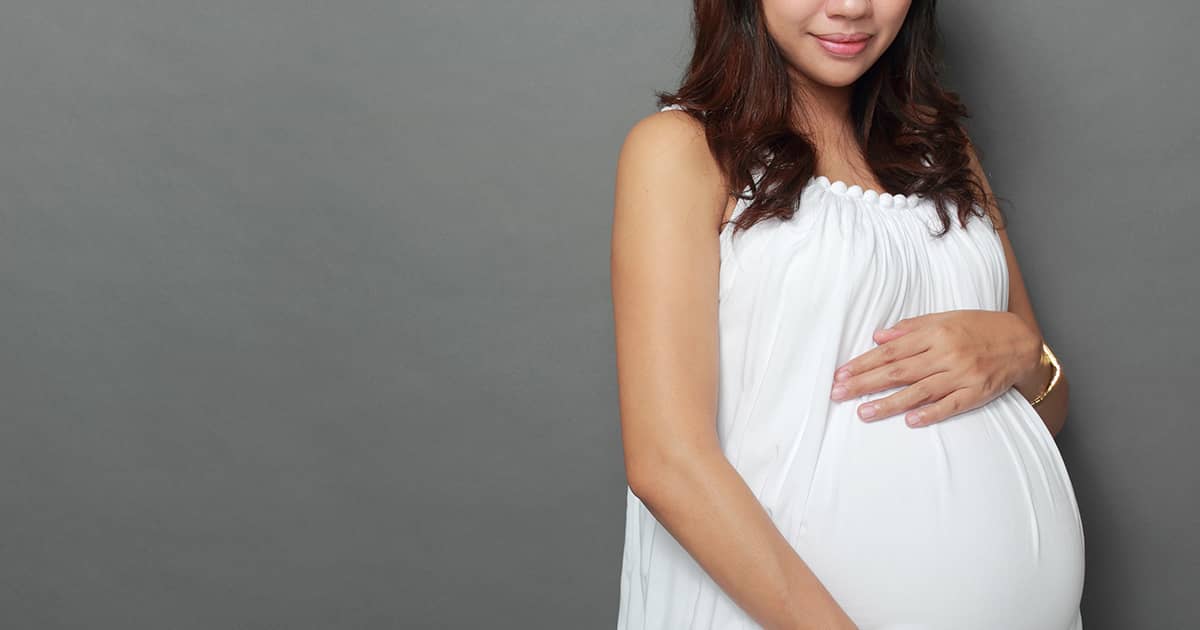 a pregnant woman in a white dress