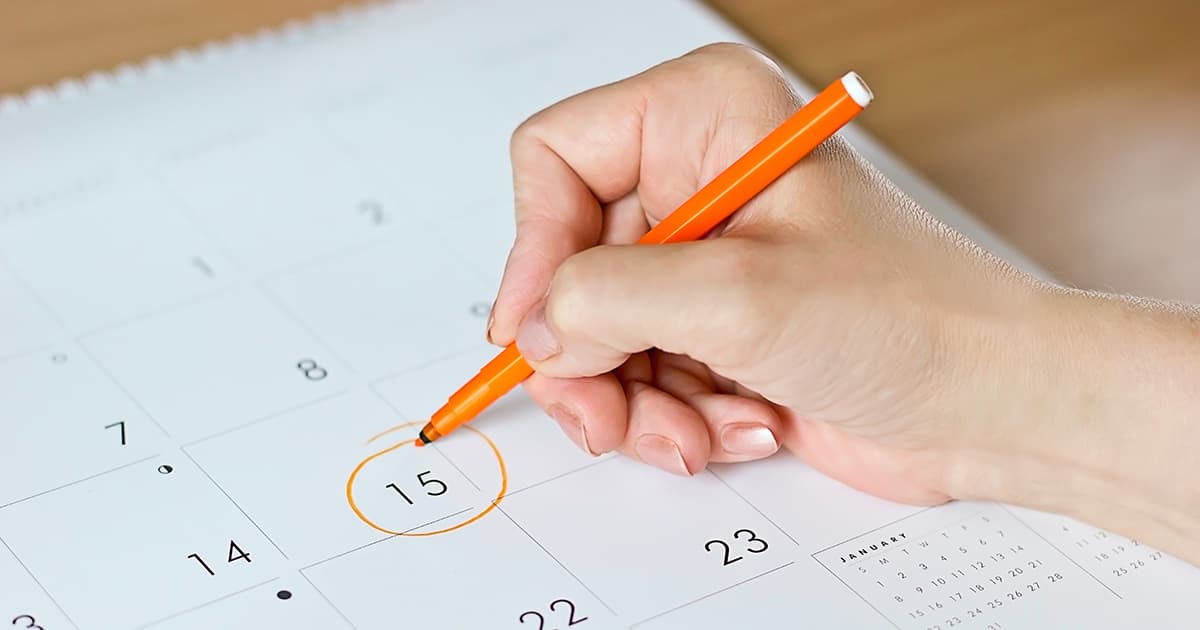 a woman circling date on a calendar