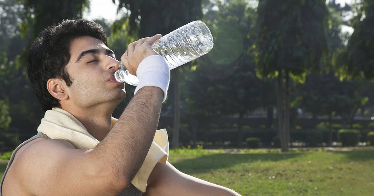 a man drinking water and exercising