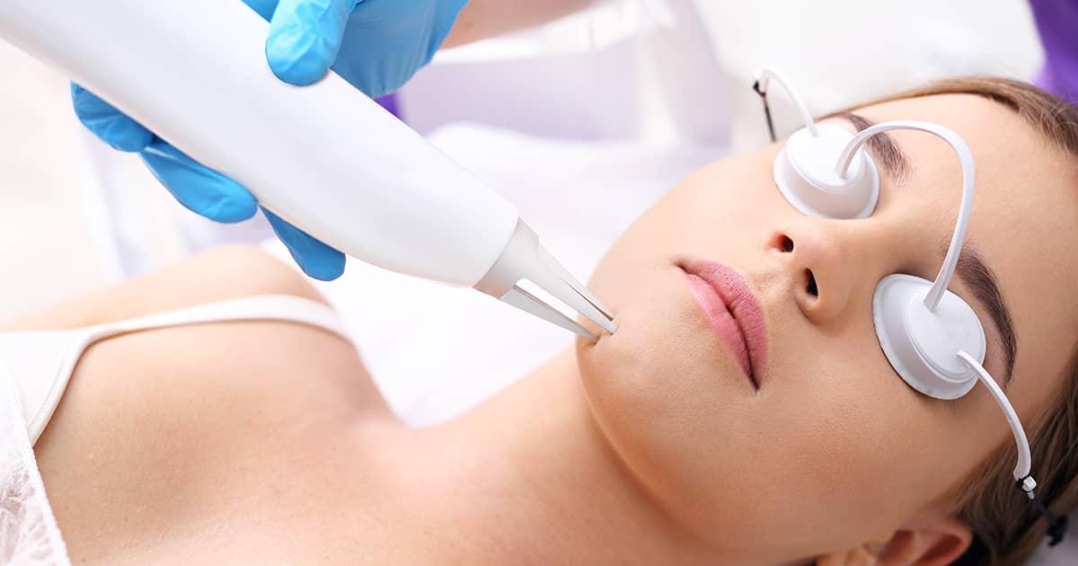 a woman undergoing laser treatment in a clinic