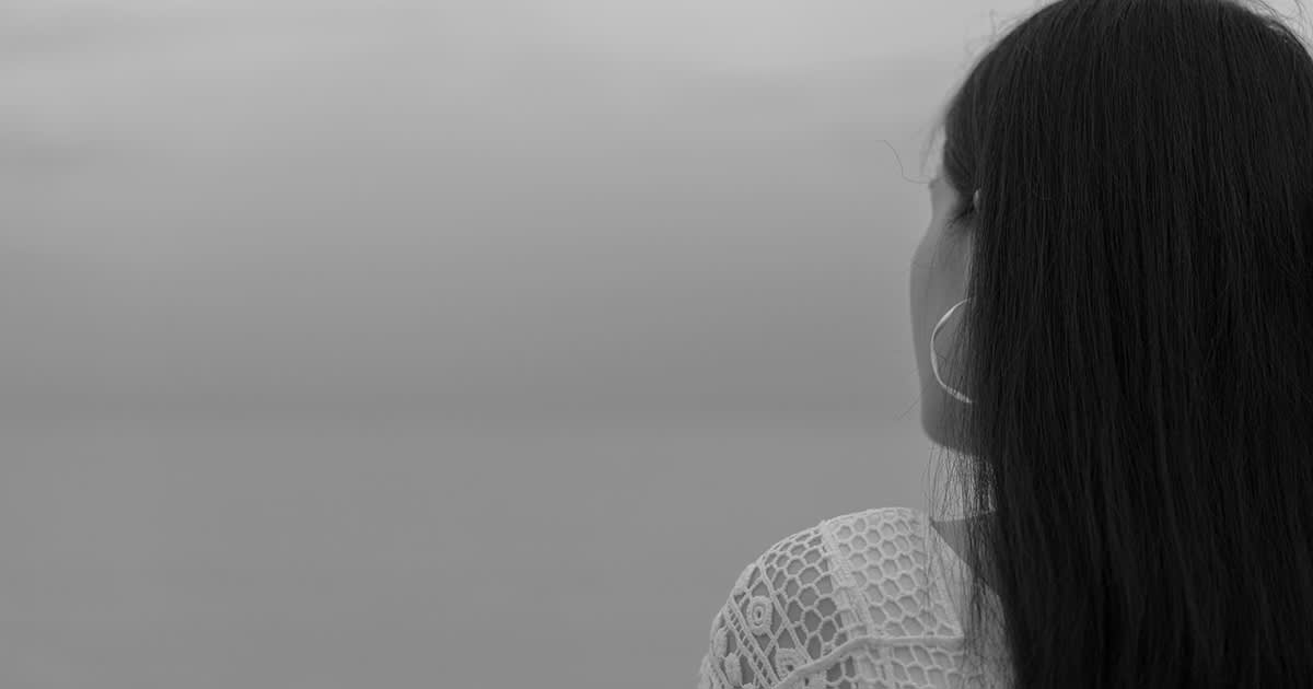 a woman looking at horizon and sea